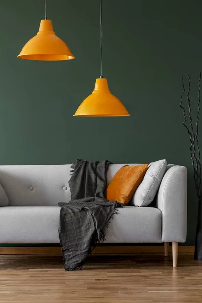 Lămpi portocalii pe un perete verde și o canapea într-un interior simplu al camerei de zi — Fotografie, imagine de stoc