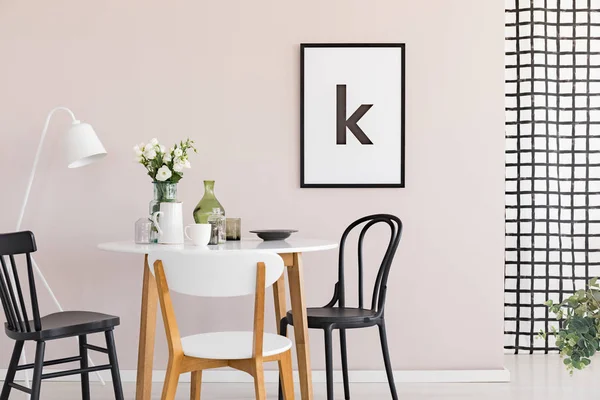 Cartel en marco negro sobre pared rosa pastel de sofisticado comedor interior con mesa redonda — Foto de Stock