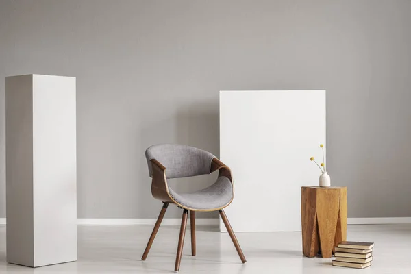Elegante silla gris y de madera y mesa de centro entre dos bloques blancos de madera — Foto de Stock