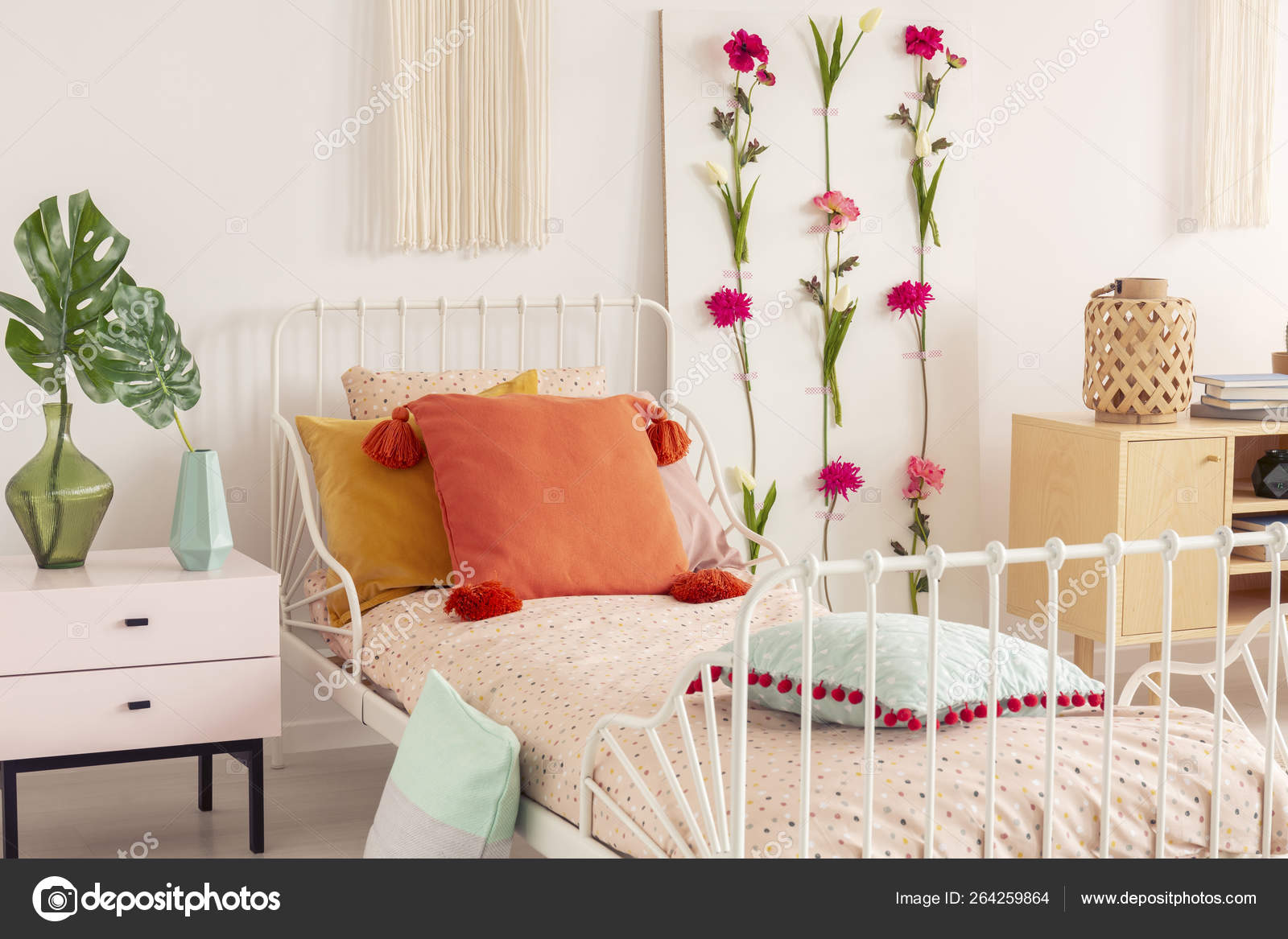 White Single Metal Bed With Colorful Pillows And Doted
