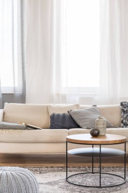Parlak oturma odası iç yastıklar ile bej kanepe önünde Yuvarlak sehpa