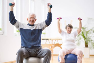 Onun emeklilik evinde ağırlıkları ile egzersiz Kıdemli adam