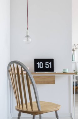 Ahşap sandalye, basit bir masa ve çıplak ampul ile parlak ev ofis iç bir dizüstü bilgisayar da Saat ekran koruyucu. Gerçek fotoğraf