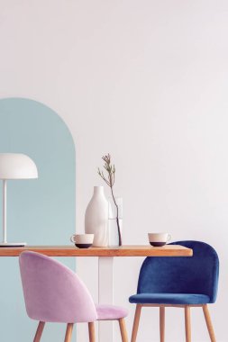 Beyaz ve mavi duvarlı süslü yemek odası iç ahşap masa üzerinde beyaz vazo