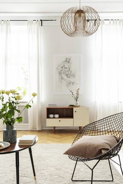 Sillón de metal industrial con almohada junto a mesa de centro de madera en habitación luminosa — Foto de Stock