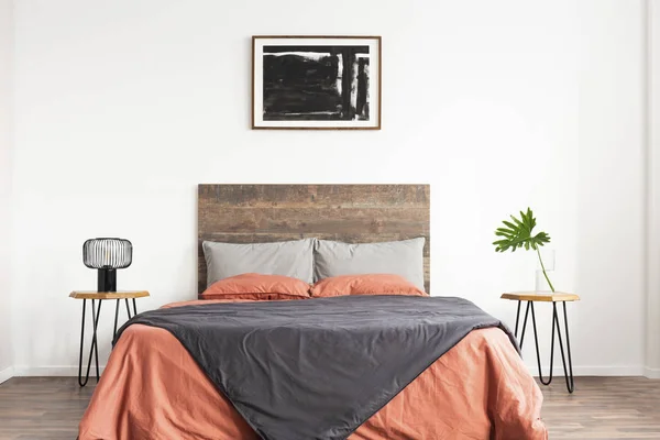 White minimal bedroom with wooden headboard and coral and grey b — ストック写真