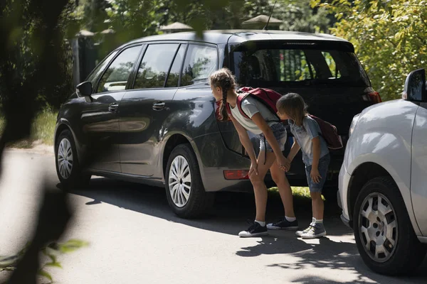 Broer en zus houden handen en staan tussen auto's proberen te rennen over straat — Stockfoto
