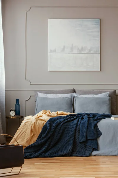 Pastelowy niebieski obraz na szarej ścianie modnej sypialni wnętrza — Zdjęcie stockowe