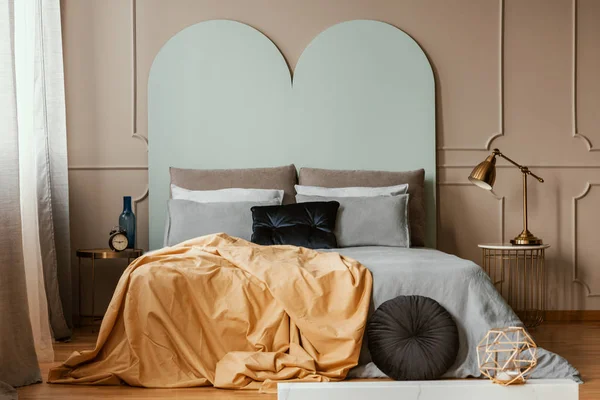 Пастельний синій узголів'я ліжка королівського розміру з затишними постільними речами та подушками — стокове фото