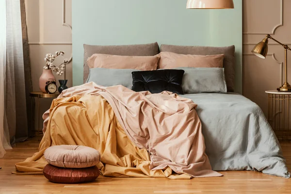 キングサイズベッドファッショナブルなベッドルームインテリアにエレガントなパステルピンク、ブルー、イエローの寝具 — ストック写真