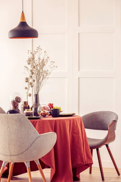 Стильные серые стулья за обеденным столом, покрытые длинной скатертью — стоковое фото