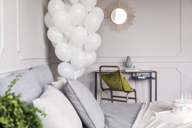 Altın ayna ve yeşil yastık ve gri yatak ve doğum günü pastası ile yatak ile sandalye ile endüstriyel şifonyer ile trendy yatak odası iç beyaz balonlar Demet