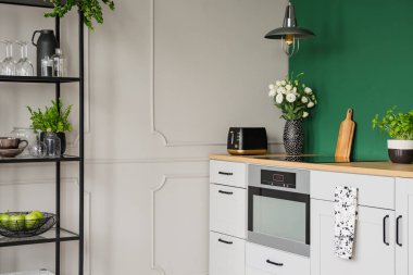 Vazo, tost makinesi, kesme tahtası ve mutfak tezgahında tencerede otlar güller