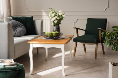 Rahat kanepe, yeşil vintage koltuk ve kase vazo ve elma gül ile ahşap sehpa ile oturma odası iç