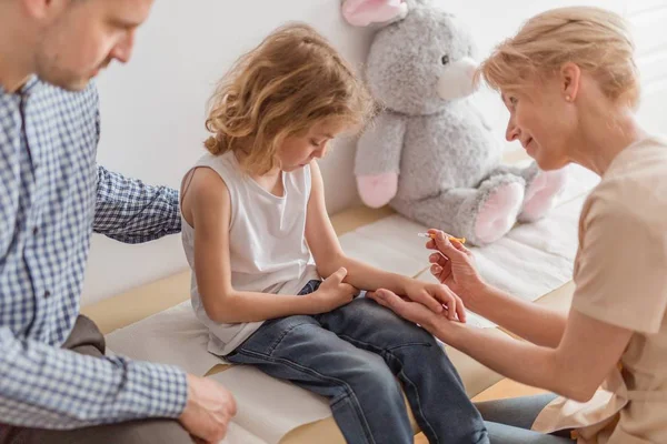 Krankenschwester spritzt einem kleinen Jungen während eines Besuchs in der Klinik eine Spritze — Stockfoto