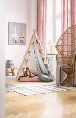 Rattan tavus kuşu sandalye poster ve kilim ile çocuk odası iç tilki oyuncak ile çadır yanında. Gerçek fotoğraf