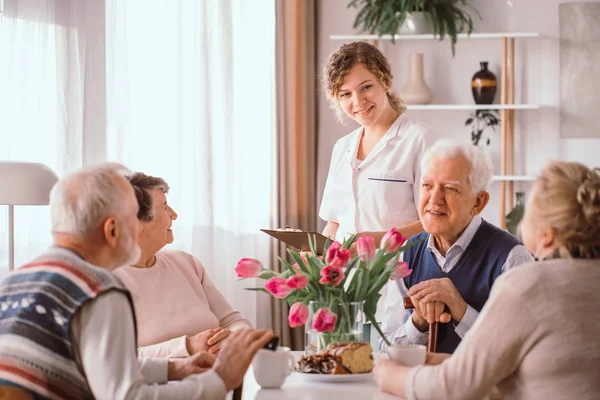 Pensionistas mayores en casa de jubilados conversando durante una tarde — Foto de Stock