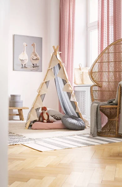 Sedia pavone in rattan accanto alla tenda con giocattolo di volpe nell'interno della stanza dei bambini con poster e tappeto. Foto reale — Foto Stock