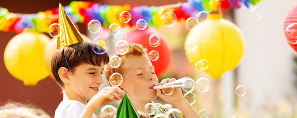 Meninos brincando com bolhas de sabão durante festa de aniversário para crianças — Fotografia de Stock