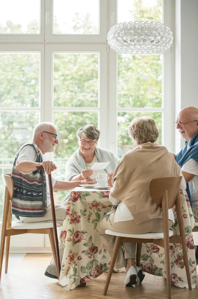 Des amis aînés passent du temps ensemble en buvant du thé et en appréciant les photos — Photo