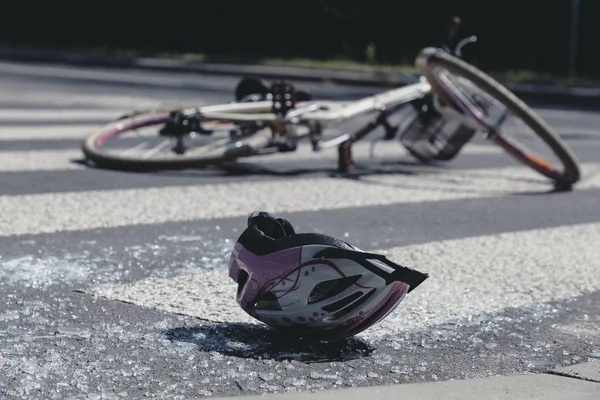 Weiß-pinkfarbener Teenager-Helm liegt nach schrecklichem Autounfall auf Glasscherben — Stockfoto