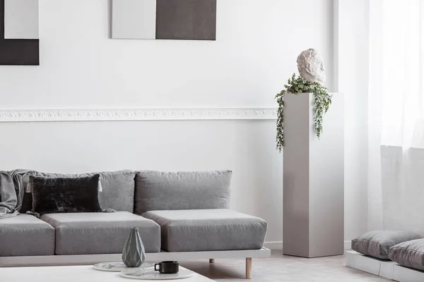 Monokromatik oturma odası iç baş ve yeşil çiçek ile gri beton sütun — Stok fotoğraf