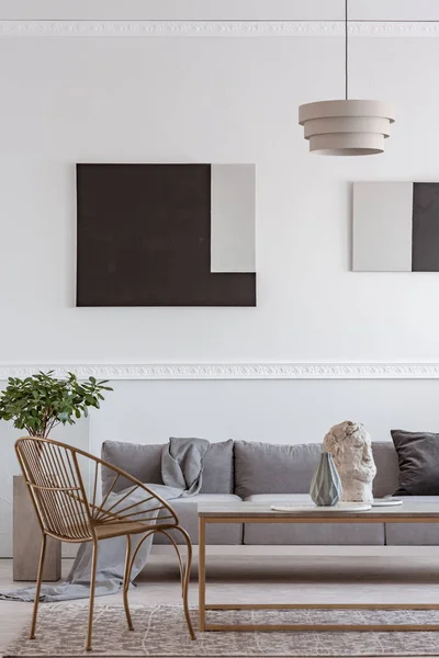 Elegante silla dorada junto a la mesa de centro con jarrón en frente de sofá gris —  Fotos de Stock