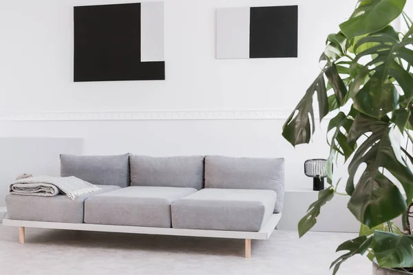 Pinturas geométricas abstractas en negro y gris en la pared blanca del interior de la sala de estar de moda — Foto de Stock