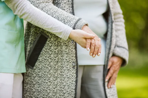 Ung hand håller äldste en. Hjälp för den äldre kvinnan — Stockfoto