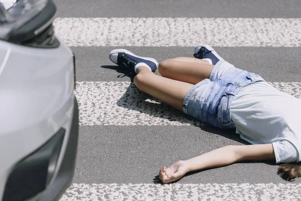 Adolescente estudante deitado na rua após terrível acidente de carro na travessia de pedestres — Fotografia de Stock