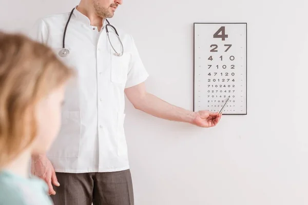 Ophthalmologist shows a small boy an eye test chart — Stock Photo, Image