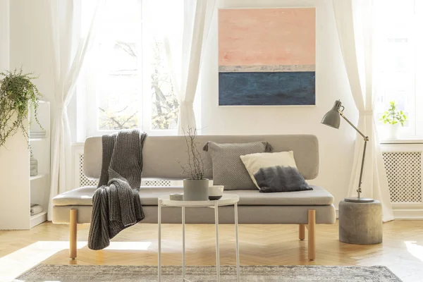 Modieuze Bank met kussens in lichte woonkamer interieur met pastel roze en blauw schilderij — Stockfoto