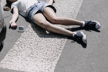 Trafik kazası kurbanı yanında yaya geçidi ve akıllı telefon üzerinde yüksek açı