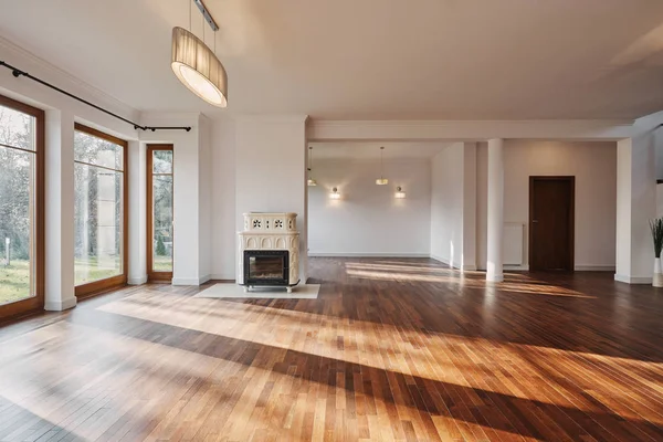 Empty interior of spacious living room interior with big windows retro fireplace and wooden floor — Stock Photo, Image