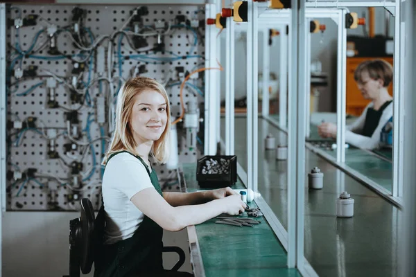 Profile view of concentrated young worker in denim overall working at factory — Stock Photo, Image