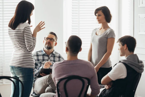 Dos mujeres de pie y hablando durante la terapia de grupo con el psicólogo — Foto de Stock