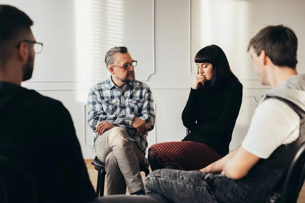 School counselor talking to depressed teenager during group therapy — Stock Photo, Image