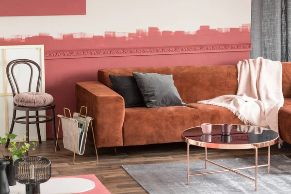 Mesa de café redonda elegante com flores em panela pequena e xícaras de chá no interior da sala de estar na moda — Fotografia de Stock