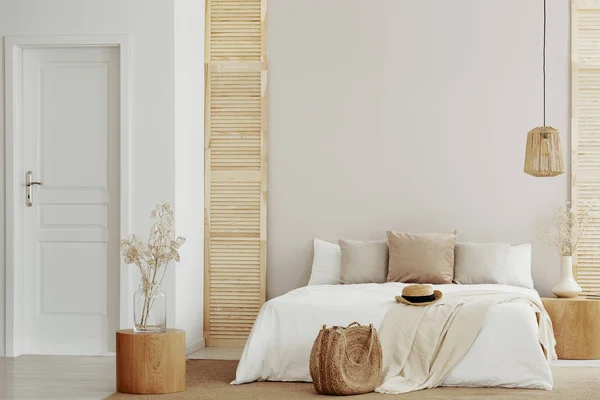 Letto king size con lenzuola bianche e beige in camera da letto elegante, copiare spazio sulla parete vuota — Foto Stock