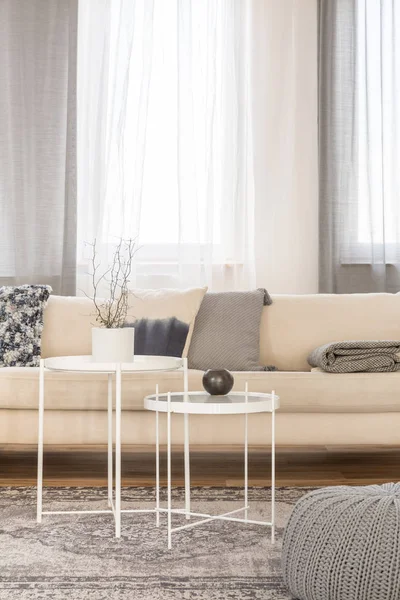 Mesas de centro industriales blancas en el interior luminoso de la sala de estar con sofá de esquina grande — Foto de Stock