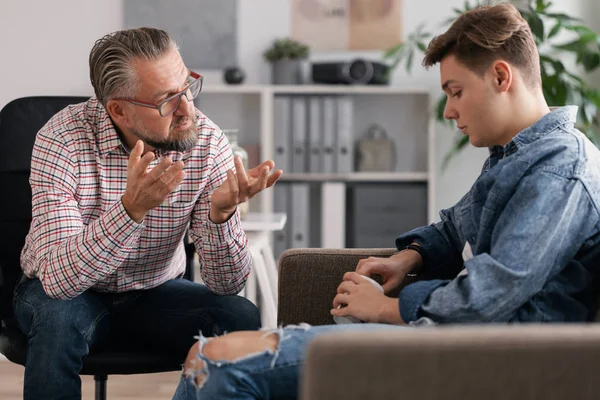 Professionele counselor en verontruste tiener tijdens therapie vergadering — Stockfoto