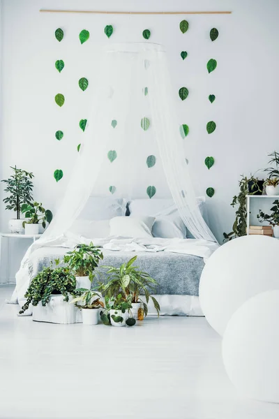 Weißes Schlafzimmer mit King-Size-Bett, Stadtdschungel und grünem Blatt an der Wand — Stockfoto
