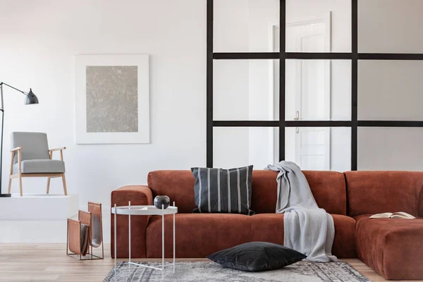 Pintura abstrata prata na moldura branca na parede da sala de estar moderna interior com sofá de canto marrom — Fotografia de Stock