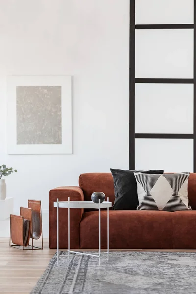 Mesa de café de metal branco ao lado de sofá confortável com travesseiros — Fotografia de Stock