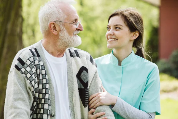 Kvinna sjuk sköterska hjälpa den äldre mannen, Foto — Stockfoto