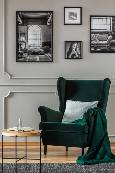 枕头在翡翠绿色扶手椅在优雅的客厅与黑色和白色的照片在灰色的墙壁上 — 图库照片