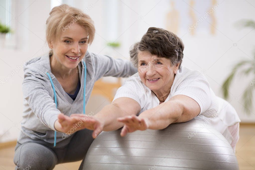 Female physiotherapist working out with senior patient in clinic