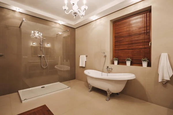 Interior de baño beige, de madera y blanco de moda con bañera cómoda y amplia ducha — Foto de Stock