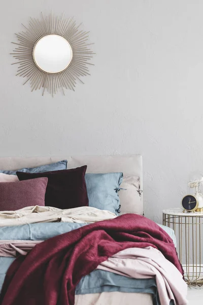 아늑한 침구가있는 편안한 침대 위의 거울과 같은 태양 모양 — 스톡 사진