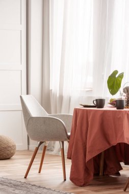 Uzun masa örtüsü ile kaplı yemek masasında şık gri sandalyeler